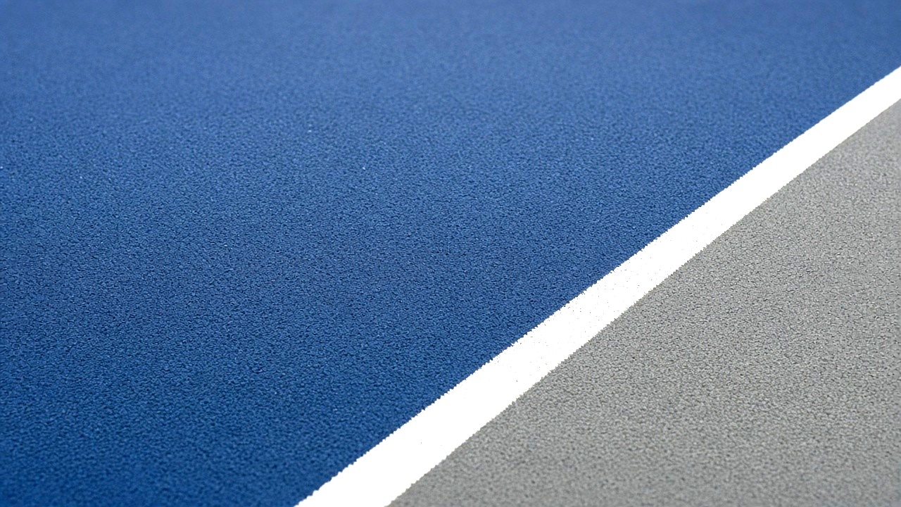 Cushioned blue indoor pickleball court at Velocity Pickleball Club