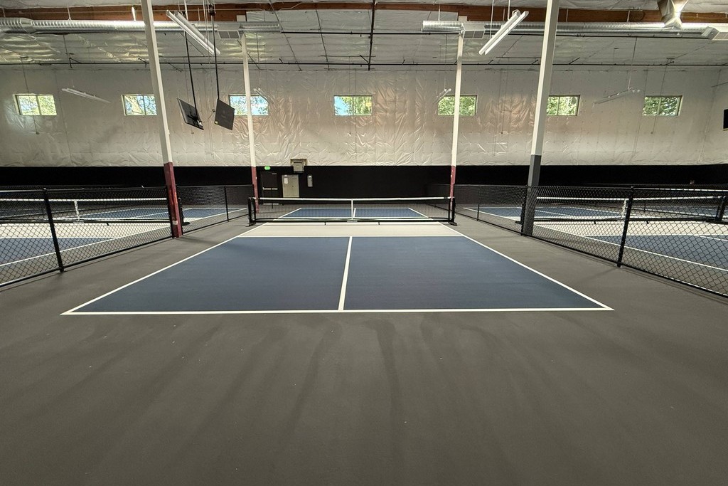 Two players dinking at the kitchen on an indoor Velocity pickleball court